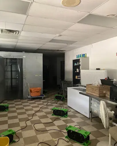 Air movers drying a wet commercial kitchen floor in North Port